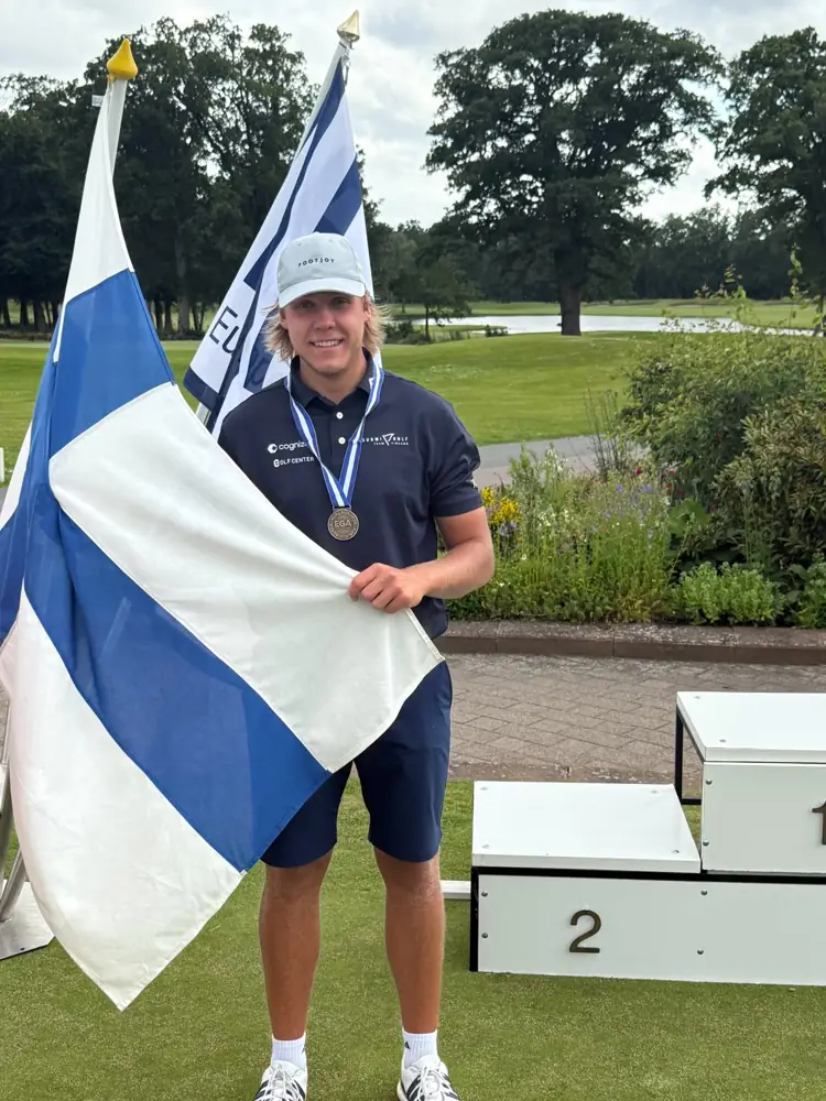 Sakke Siltala mitali kaulassa Suomen lipun kanssa
